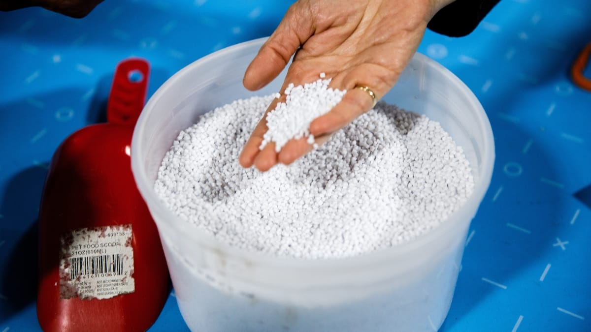 hand sifting plastic pellets in a bucket
